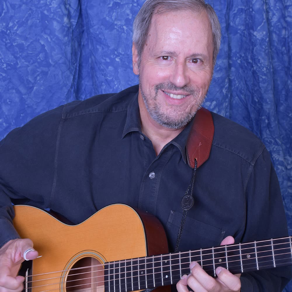 Studio portrait of Joe Caporaso with his acoustic guitar